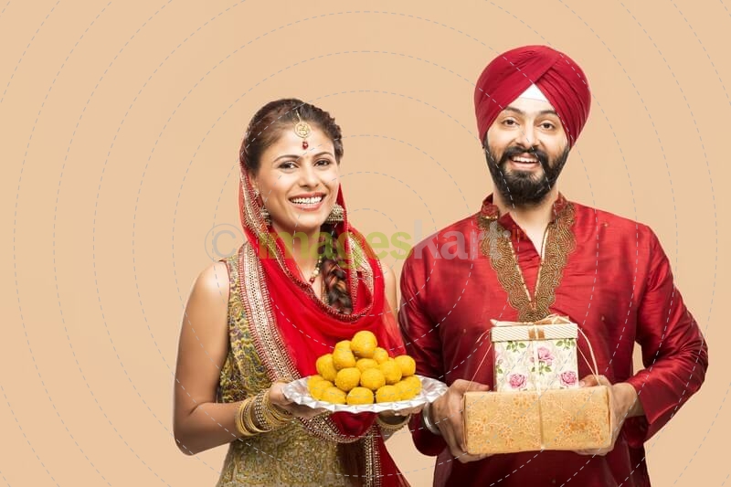sikh couple posing with gifts and sweets