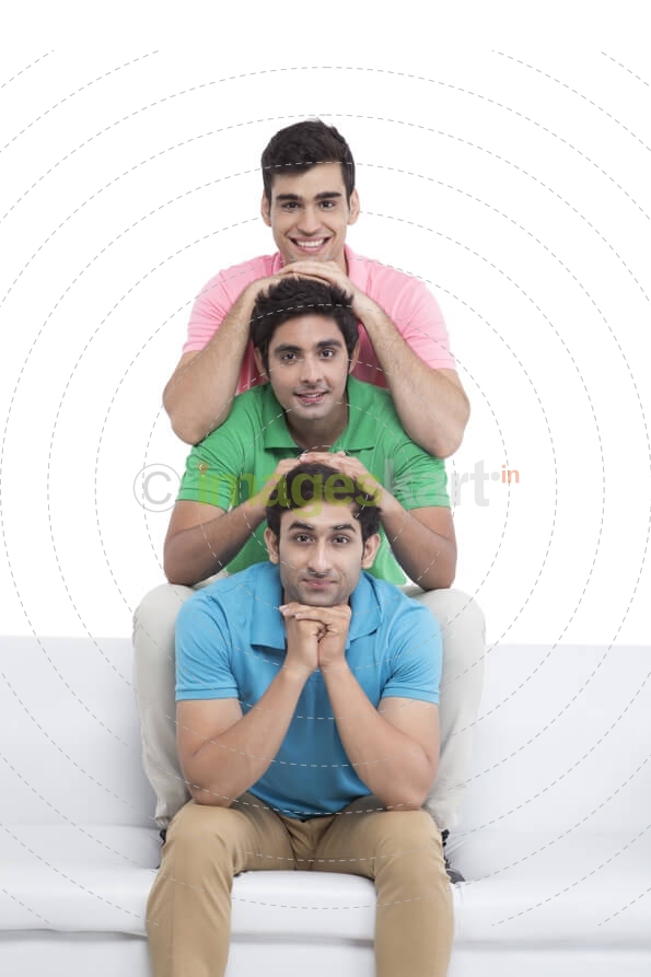 three young friends sitting in a row and posing 