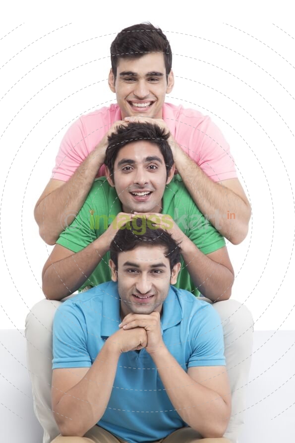 three young friends sitting in a row and posing 