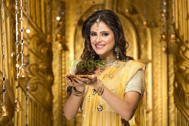 woman in traditional wear with diya 