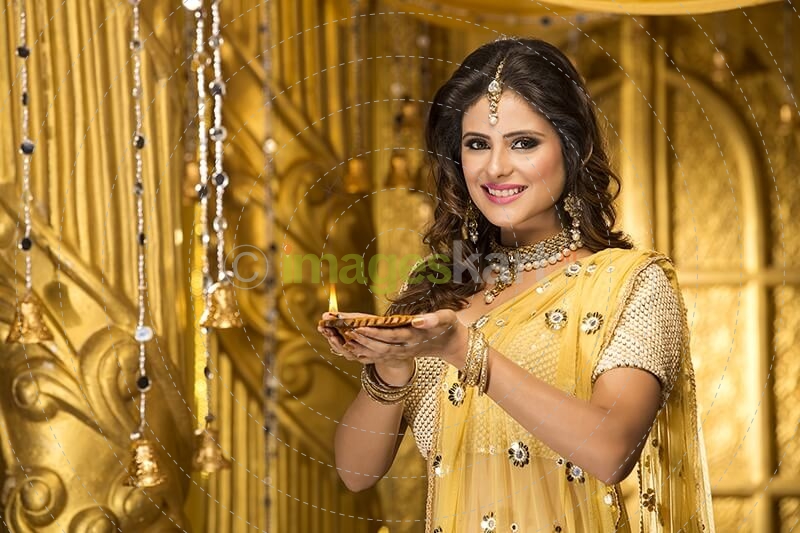 woman in traditional wear with diya 