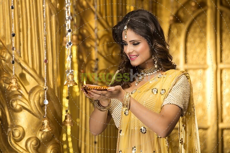 woman in traditional wear with diya 