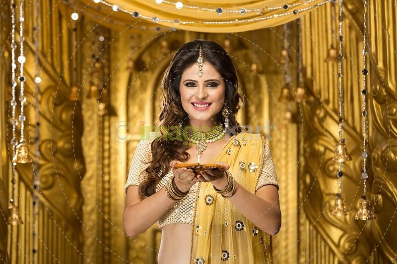 woman in traditional wear with diya 