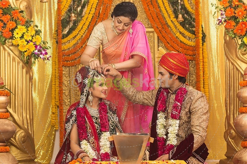 groom applying sindoor to wife