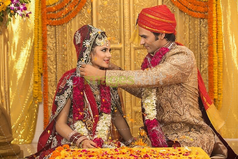 groom applying sindoor to wife