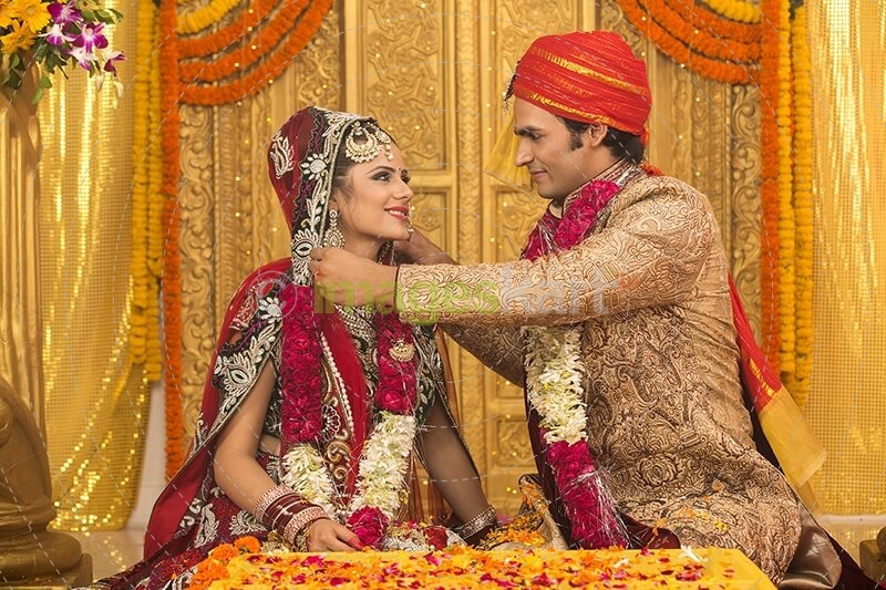 groom applying sindoor to wife
