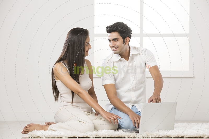 couple at home working on laptop