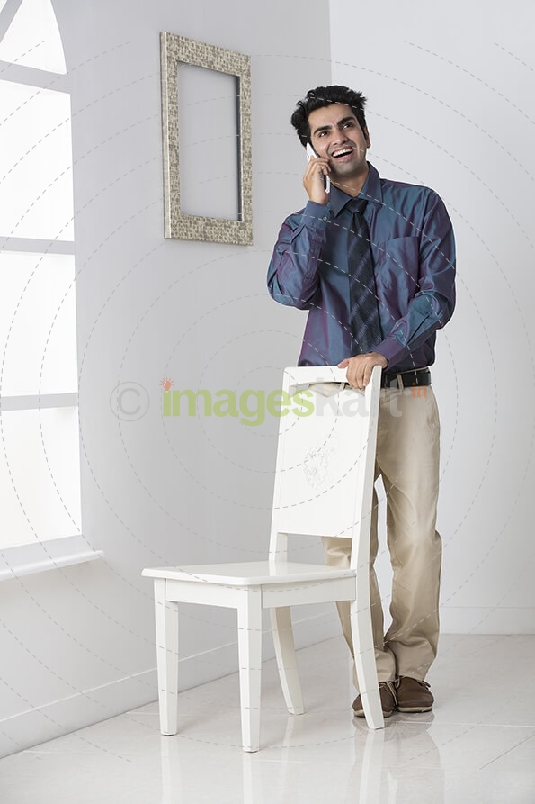 man in formals talking on phone at home