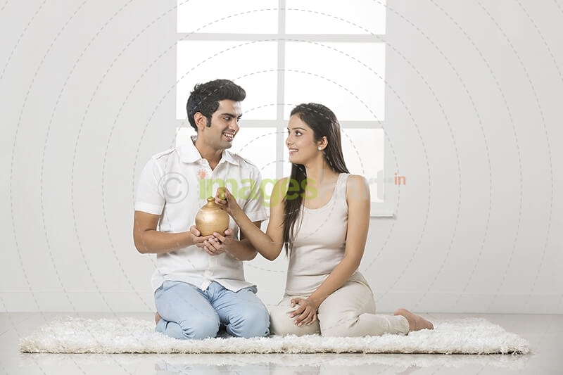 newly wed couple at new home with piggy bank