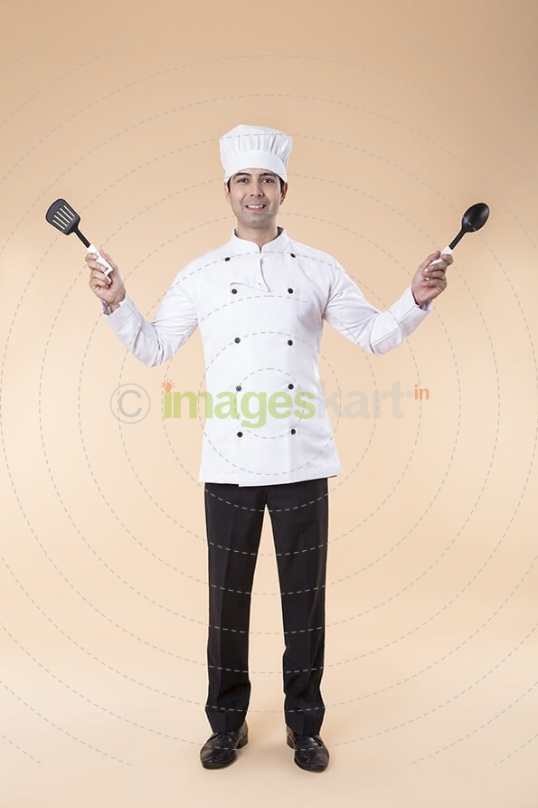 chef posing with spatula and ladle
