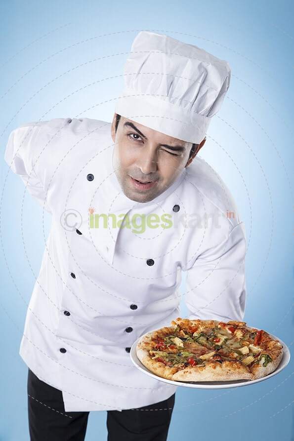 chef posing with pizza