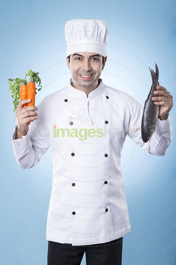 chef posing with fish and carrots