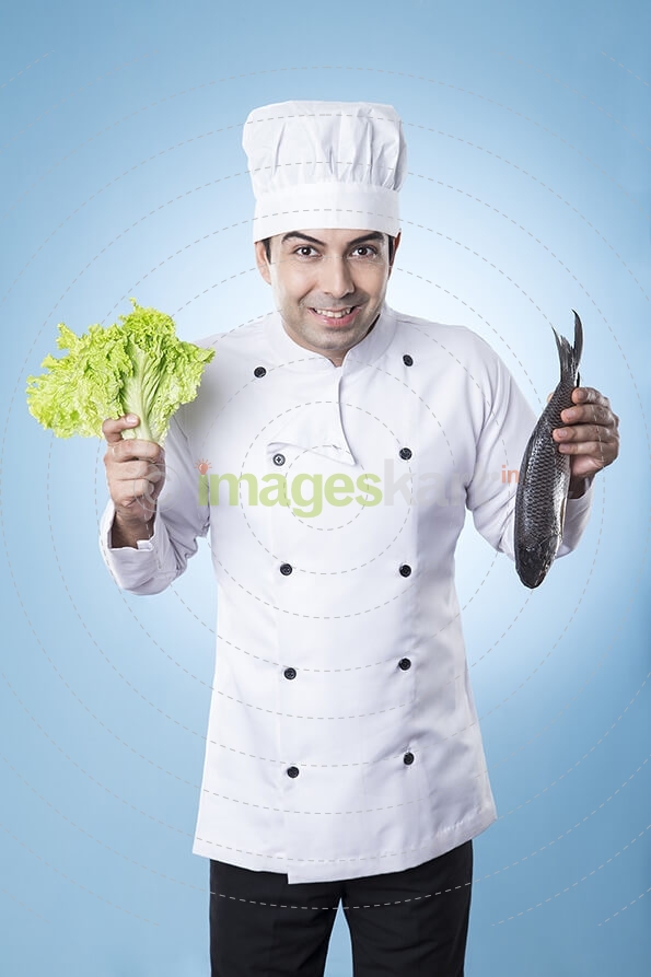 chef posing with fish and lettuce