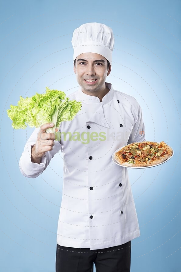 chef posing with pizza and lettuce