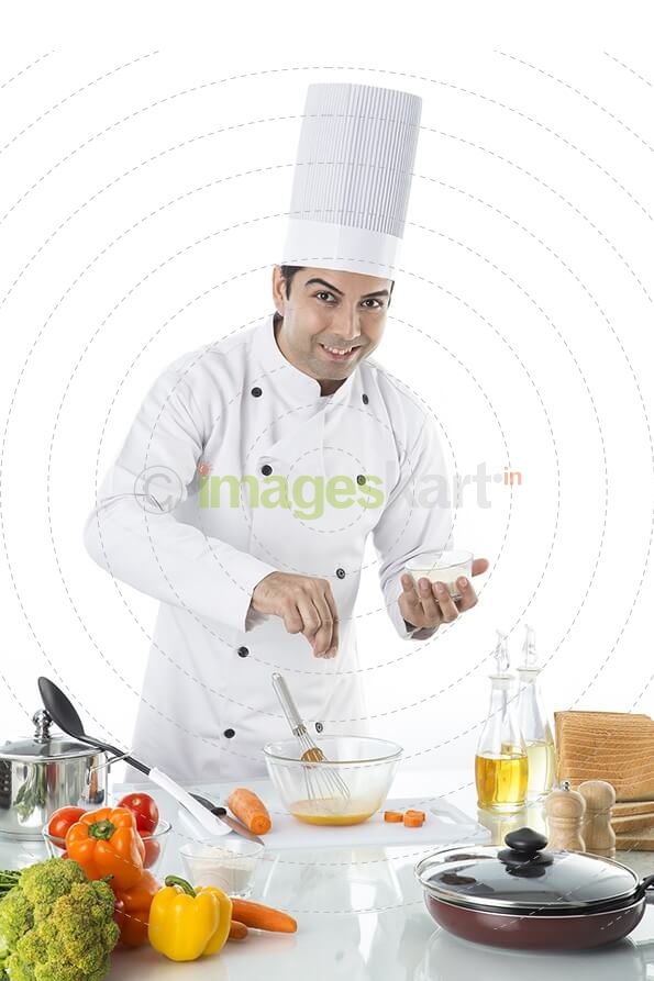chef adding salt to the bowl 