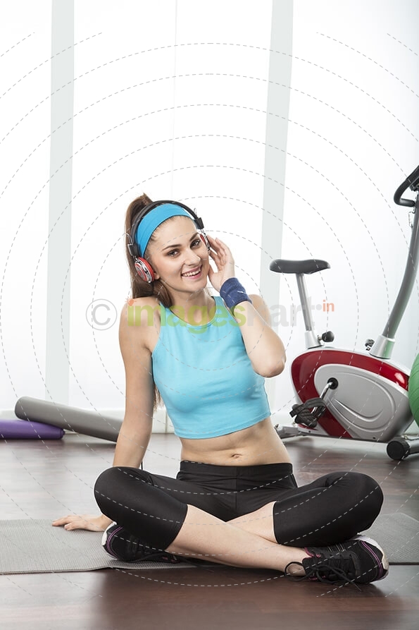 girl in gym wear with headphones 