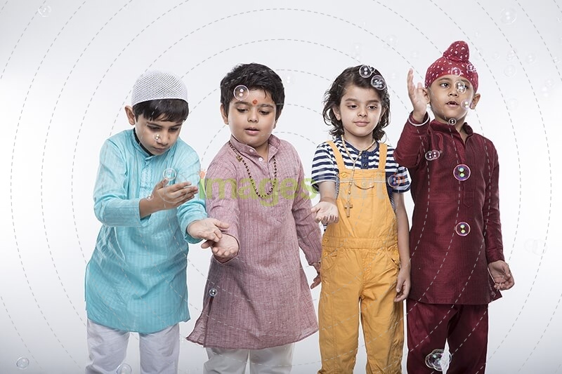 four kids from different religion playing with bubbles