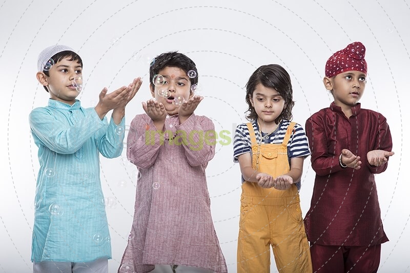 four kids from different religion playing with bubbles