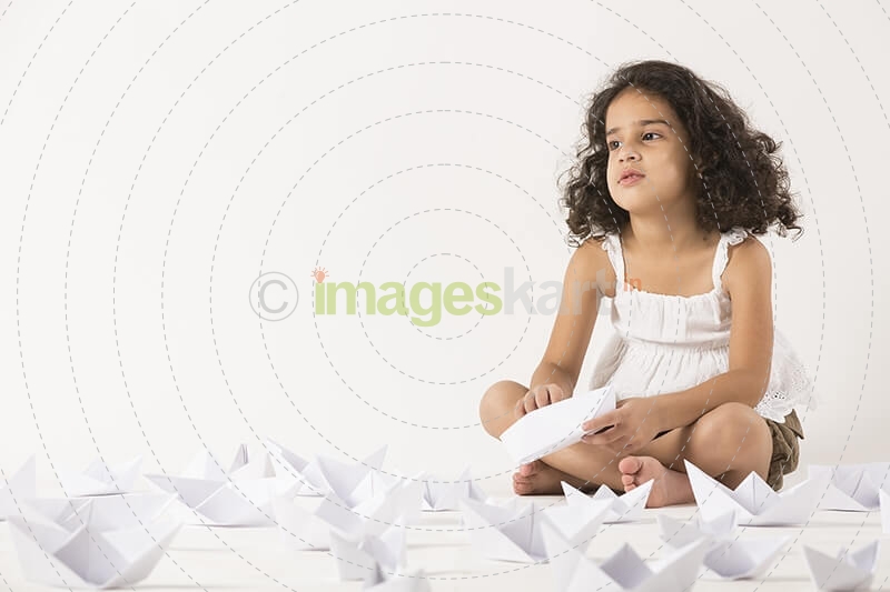 cute little girl playing with paper boat 