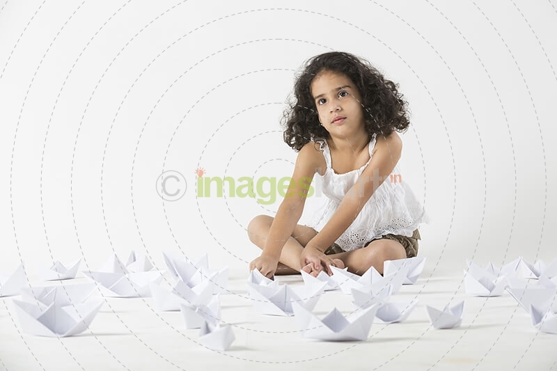 cute little girl playing with paper boat 