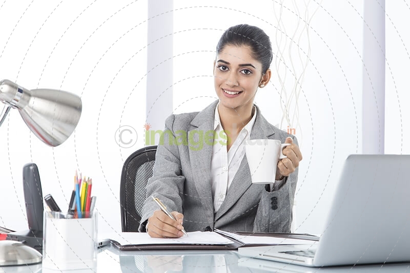 corporate woman having coffee while working 