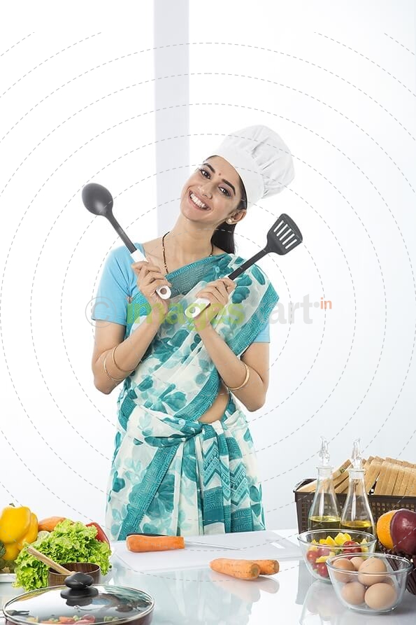 Indian housewife posing with spatula and ladle
