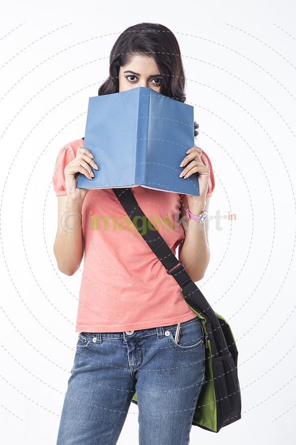 college girl hiding face with book