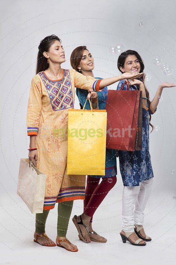 Three Indian women with shopping bags