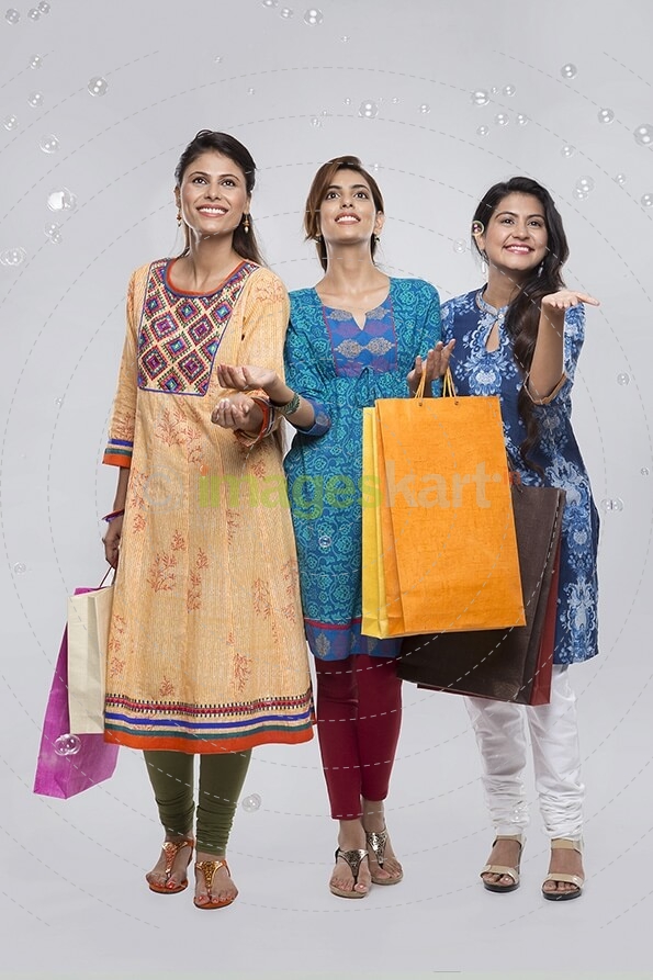 Three Indian women with shopping bags