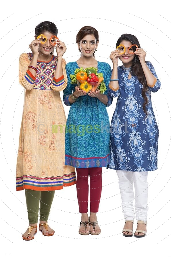 three women standing together holding vegetable in hand