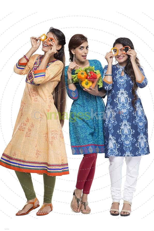 three women standing together holding vegetable in hand