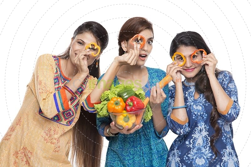 three women standing together holding vegetable in hand
