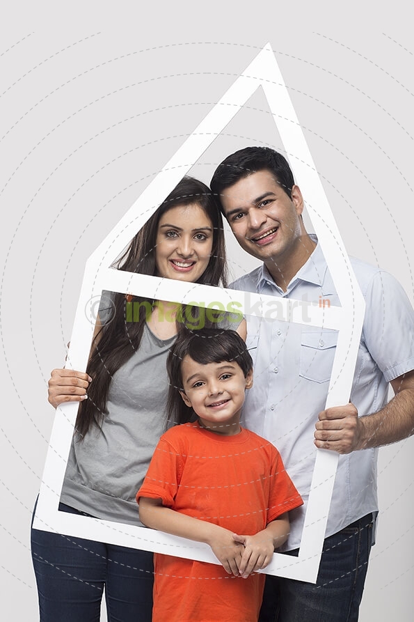 family posing with house shaped frame