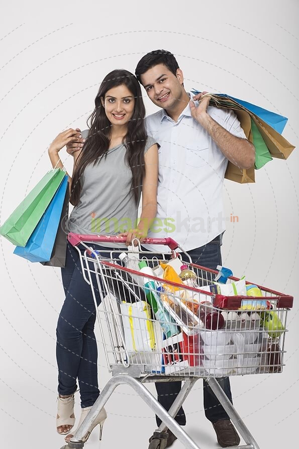 Couple posing with shopping bags and shopping kart