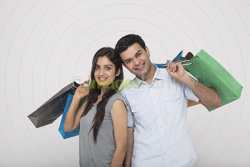 Couple posing with shopping bags while looking at camera