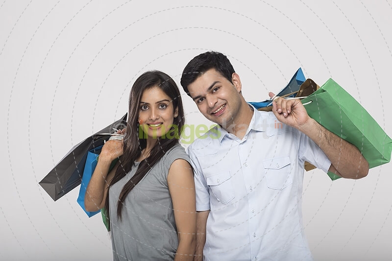Couple posing with shopping bags while looking at camera