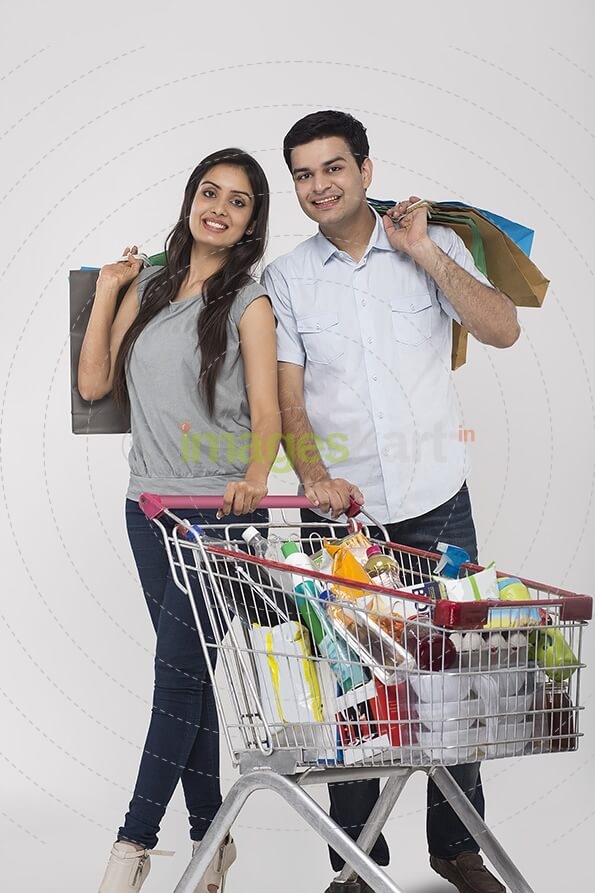 Couple posing with shopping bags and shopping kart