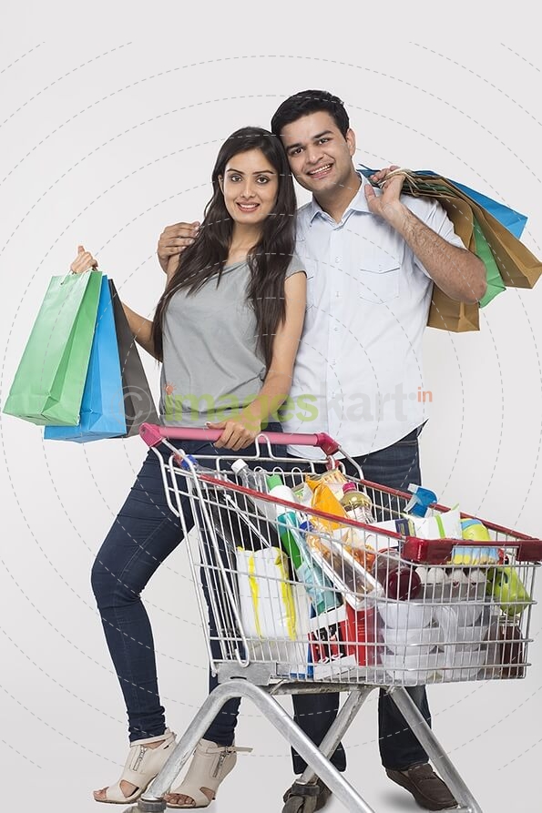 Couple posing with shopping bags and shopping kart