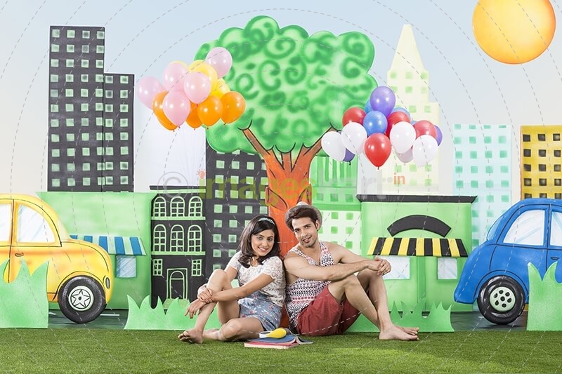 couple sitting back to back in garden holding balloons