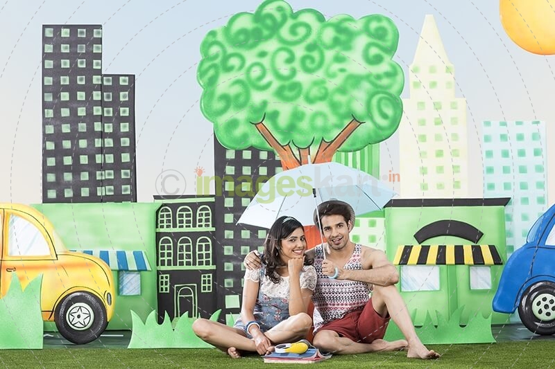 couple holding umbrella sitting in garden