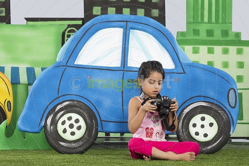 young girl clicking a photograph from camera in the park