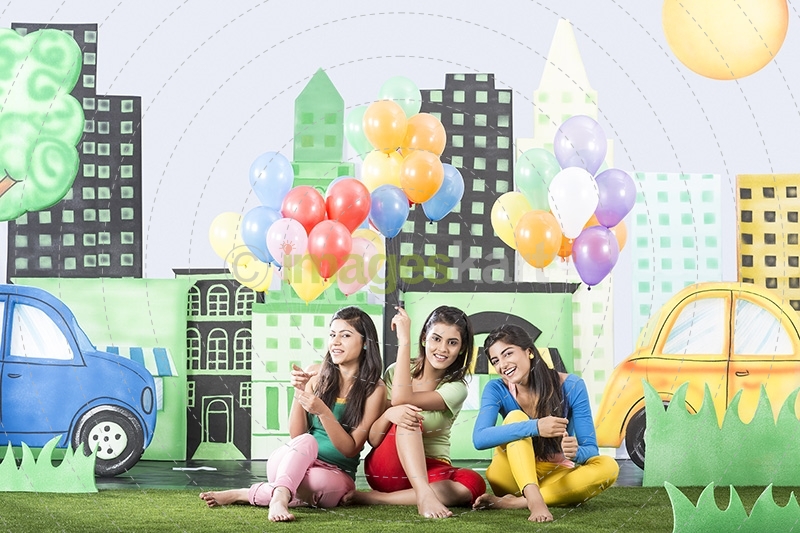 Three girls holding balloons