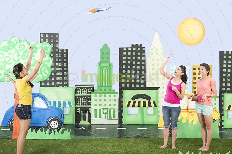 Three girls playing with kite in the park