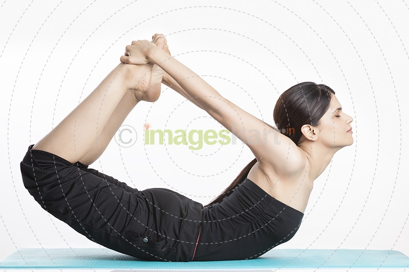 young woman yoga exercise practicing dhanurasana