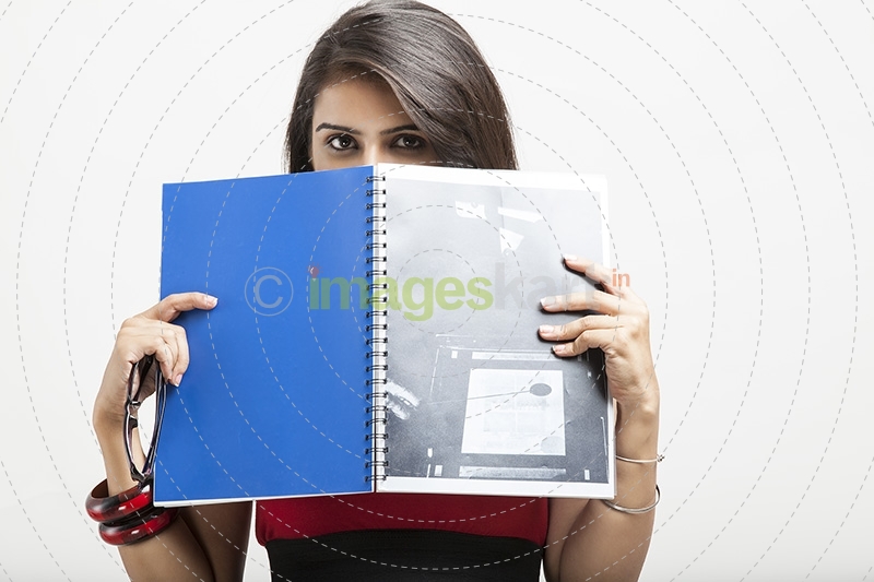 college girl posing while holding a text book
