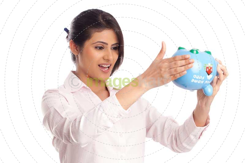 beautiful corporate woman looking at the piggy bank