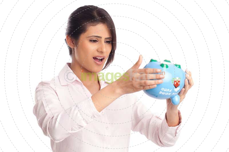 beautiful corporate woman looking at the piggy bank