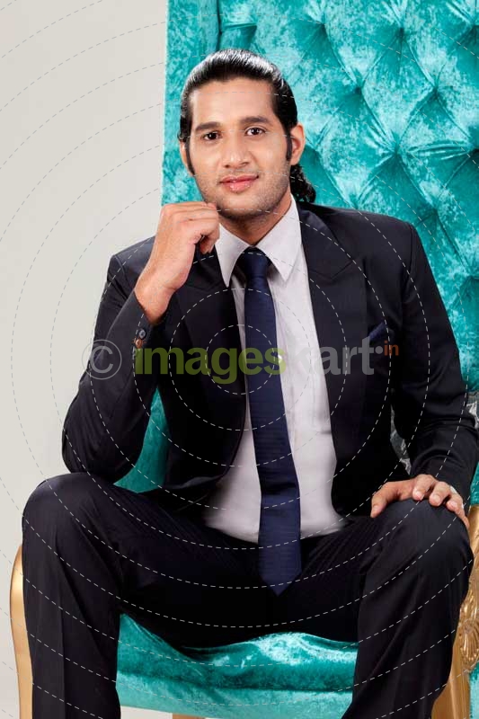 young business man posing while sitting on chair 