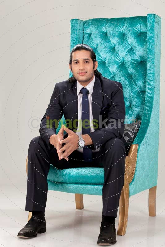 a business man sitting on chair posing for the camera