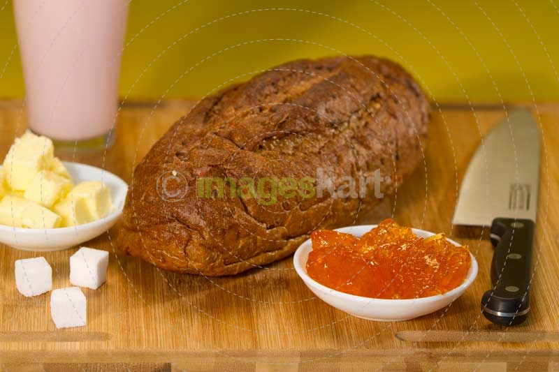 bread,butter,jam and sugar cubes on a wooden table